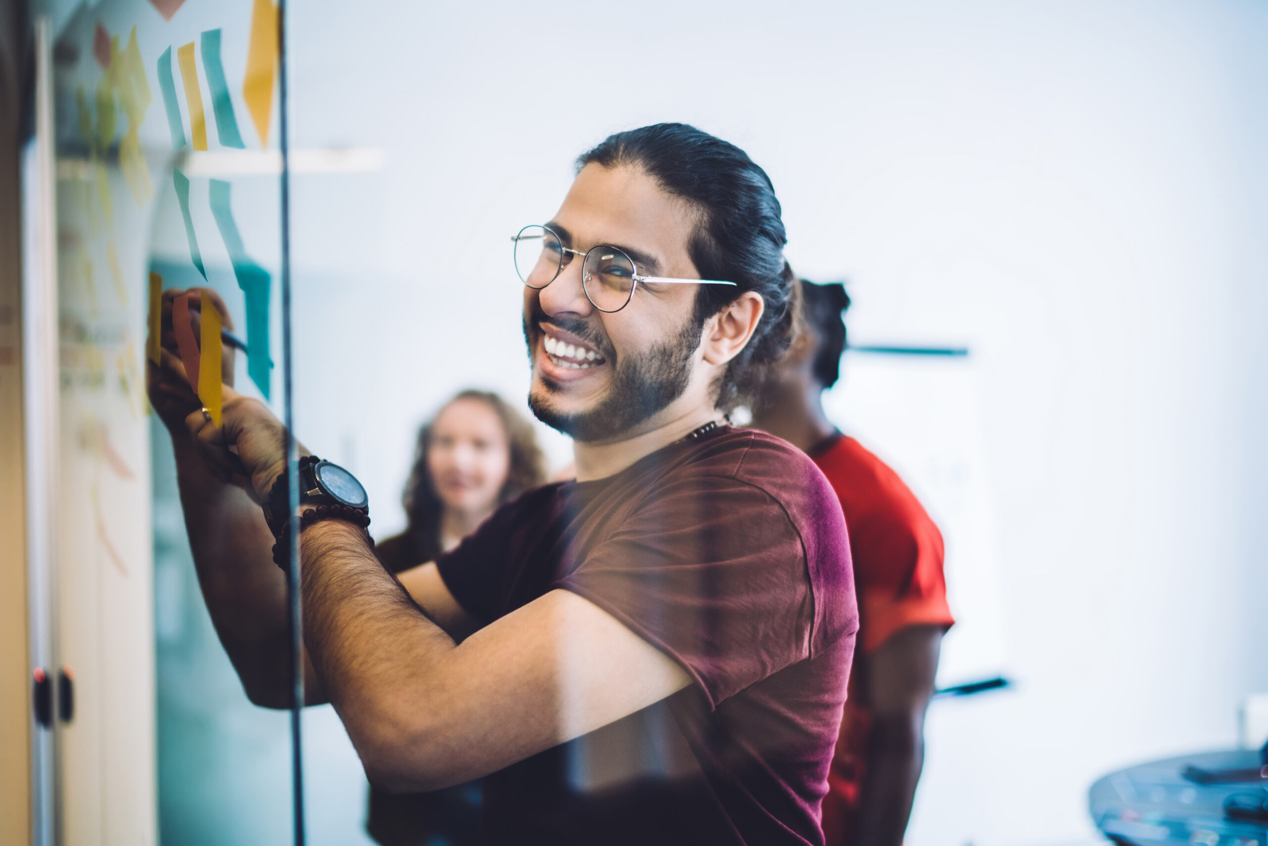 Laughing man writing on glass board